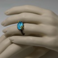 Oval-shaped silver ring with gold and turquoise doublet stone