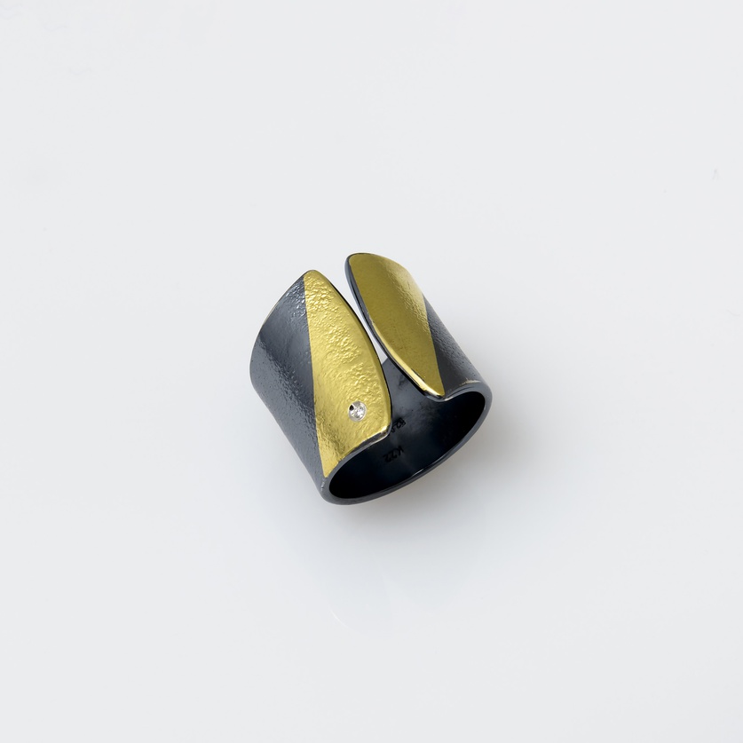 Silver ring in modern style with gold inlay and a small diamond