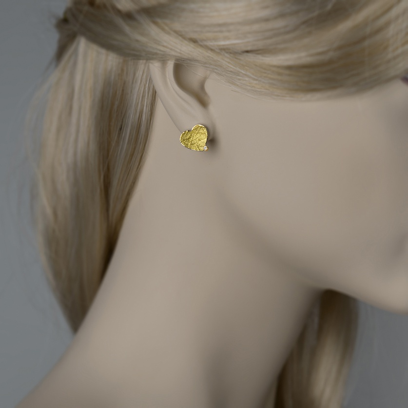 Heart shaped stud earrings in silver and gold with small diamonds
