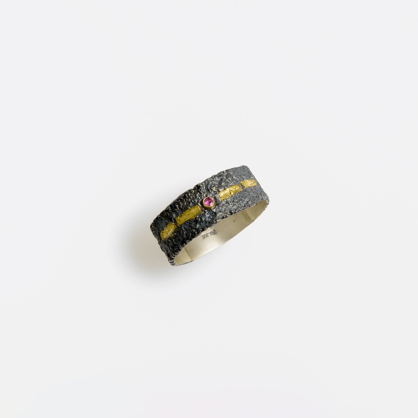 Silver ring with golden stripe and ruby