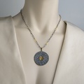 Striking round pendant in silver and gold inlay with small rubies