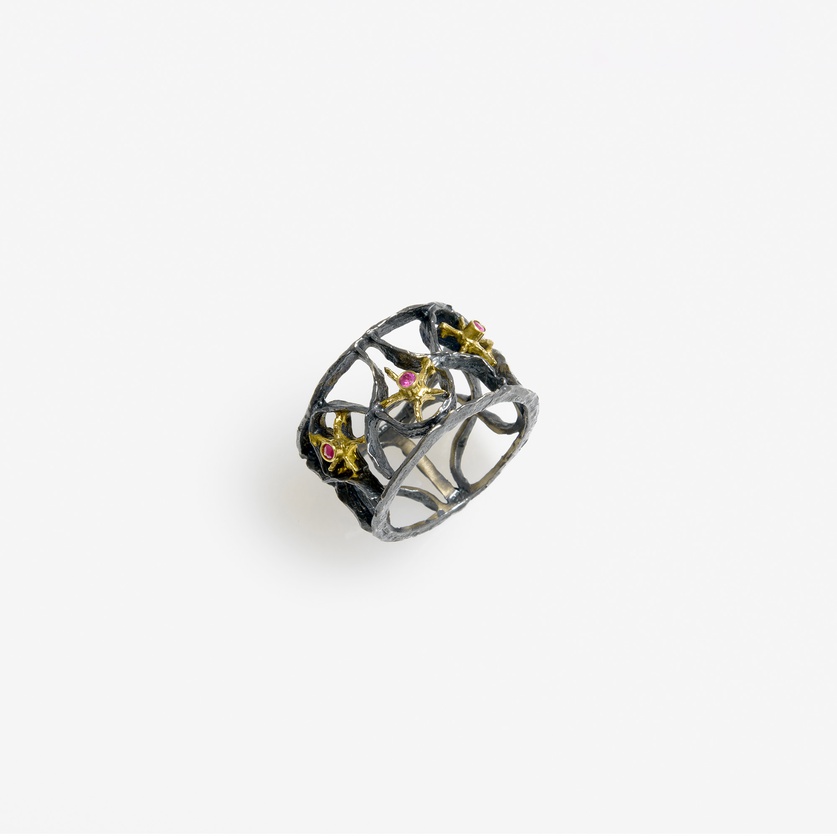 Silver ring of intricate detail with gold inlay and rubies