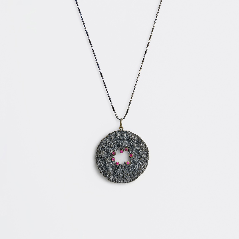 Round pendant with rough surface in silver, gold inlay and rubies