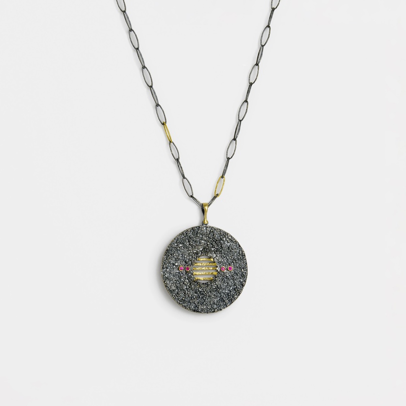 Striking round pendant in silver and gold inlay with small rubies