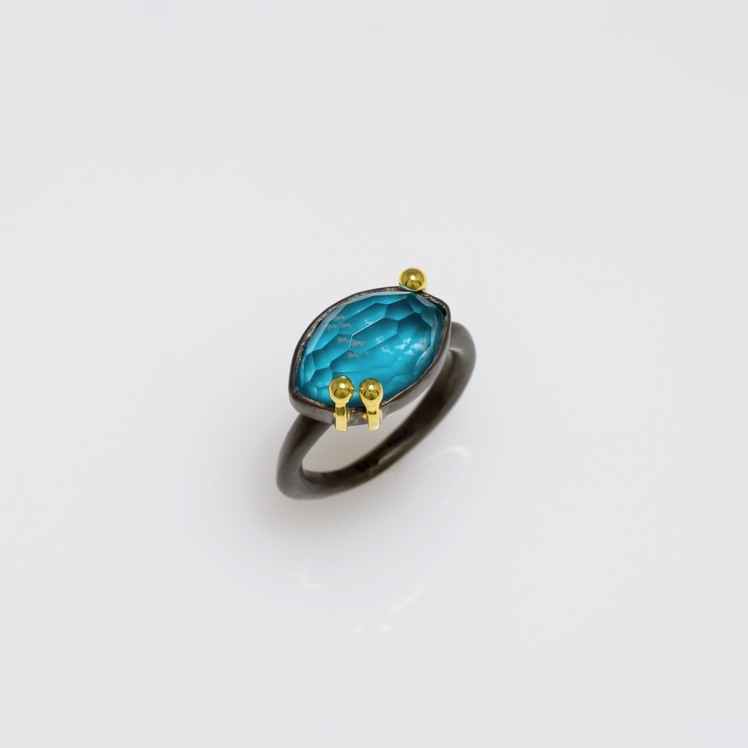 Oval-shaped silver ring with gold and turquoise doublet stone